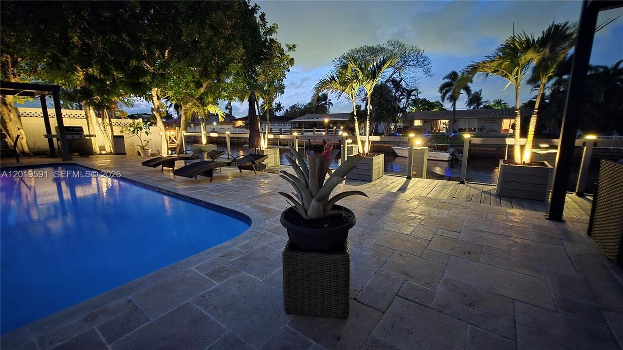 Resort-style heated pool illuminated at night with relaxing tropical ambiance and upscale entertainment space.