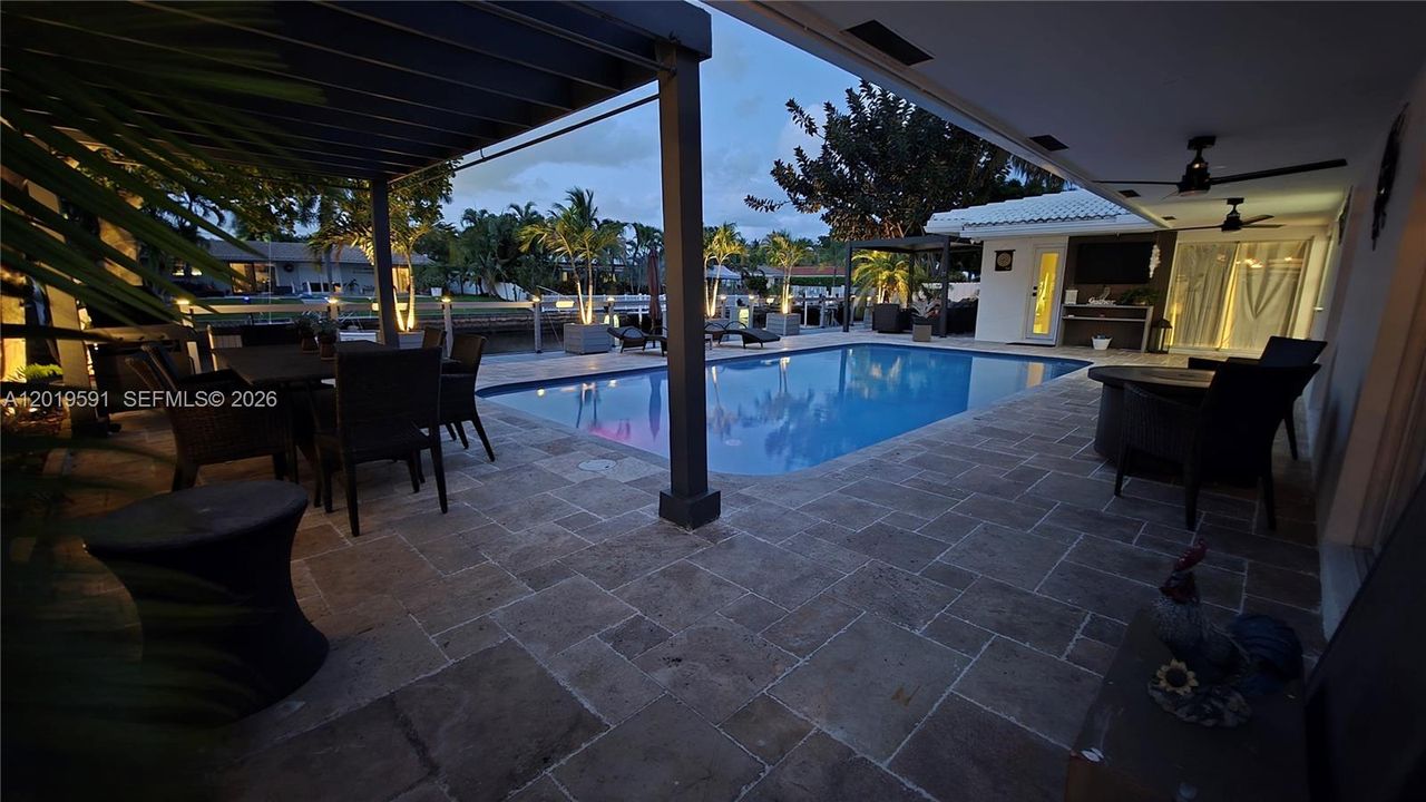 Evening poolside ambiance with resort-style lighting, tropical atmosphere, and luxury outdoor relaxation.