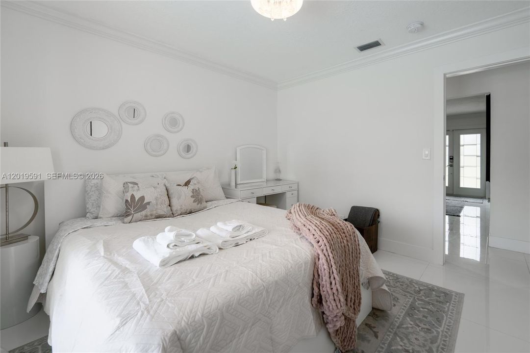 Cozy modern guest bedroom with elegant décor, soft natural lighting, and relaxing vacation retreat atmosphere.
