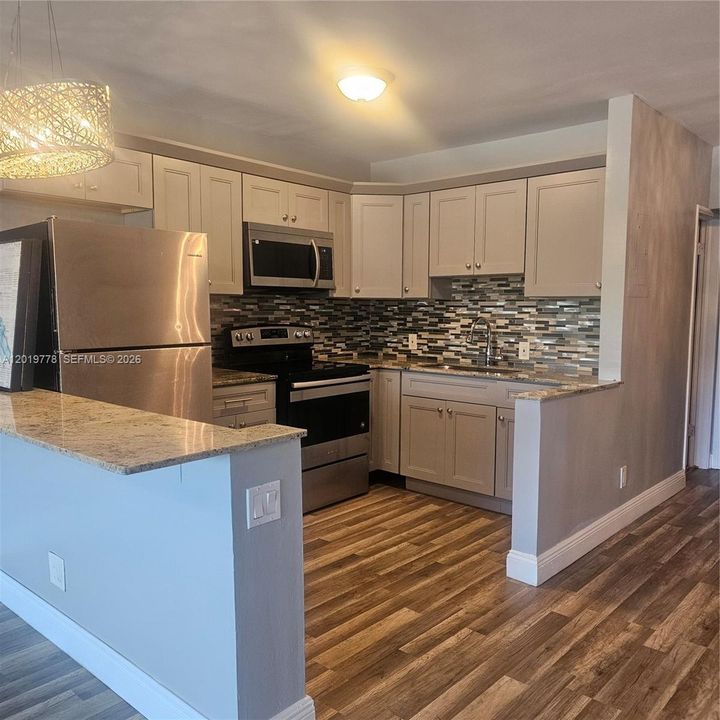 newer kitchen, tile backsplash, casual dining counter/workspace