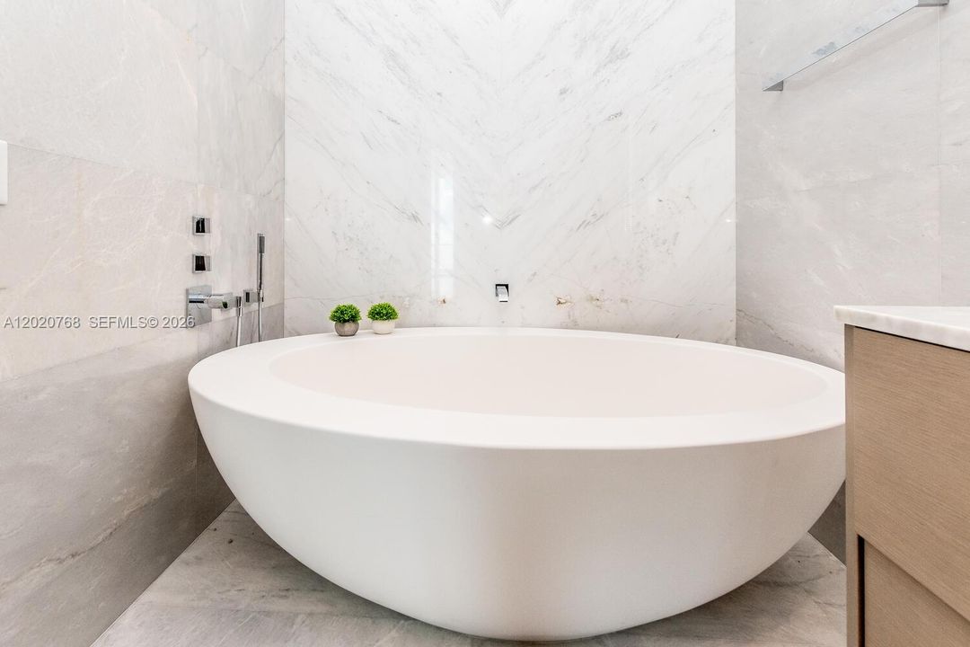 Master Bathroom features a book-matched marble wall, marble flooring along with European Dornbracht® fixtures.