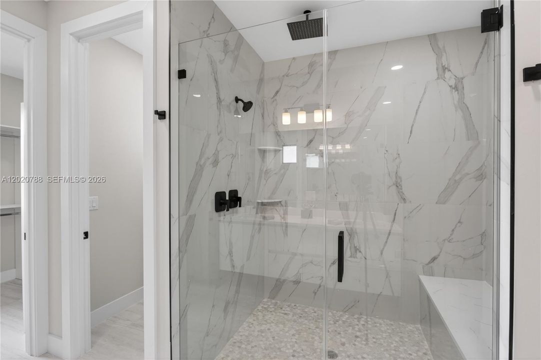 OVERSIZED PRIMARY BATHROOM features a spacious WALK-IN SHOWER with built-in bench for a luxurious spa-like experience!