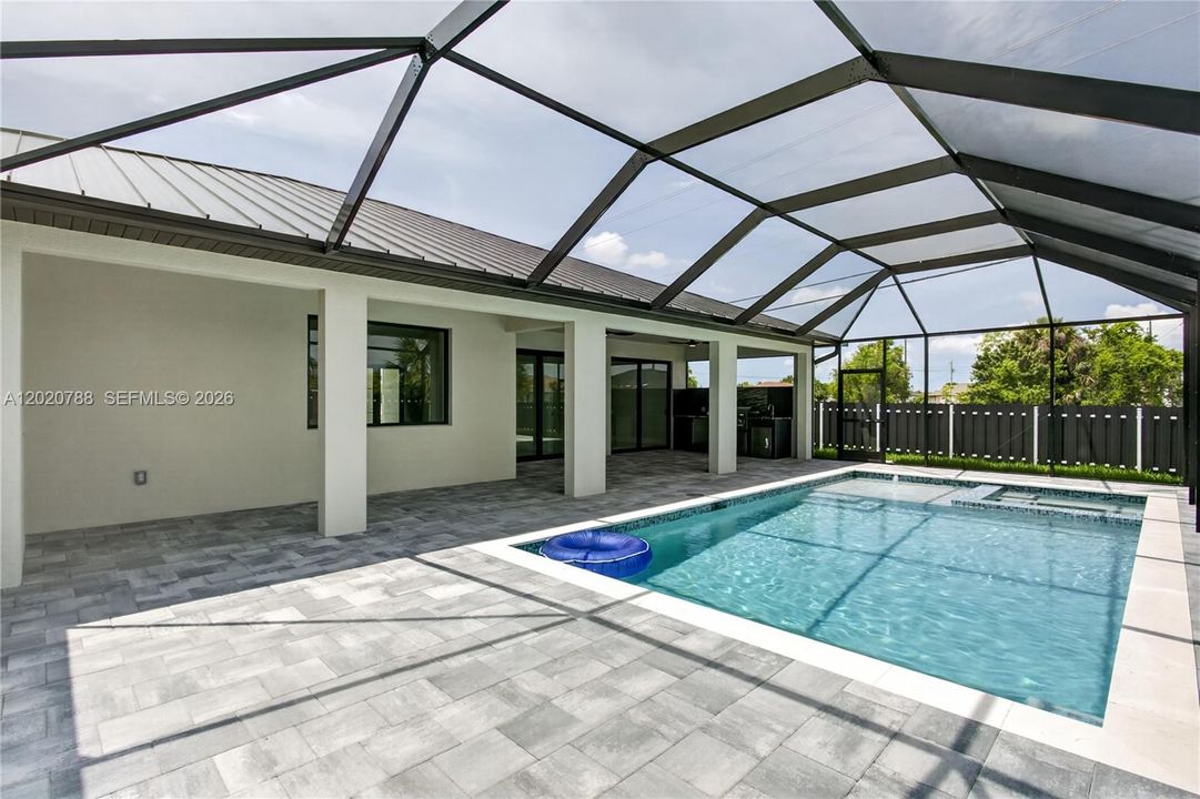 Step outside to SCREENED LANAI w/ HEATED POOL & SPA, landscaped surrounding