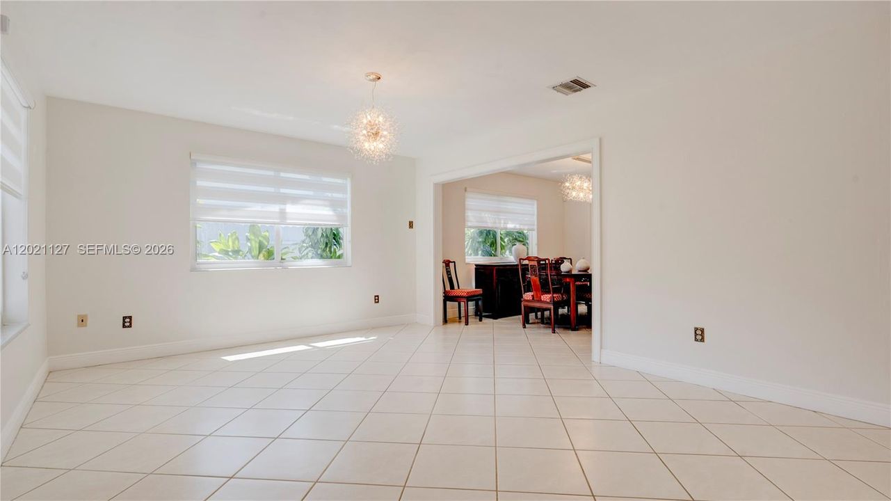 3613. This is the back 3/2 unit. The House is filled with natural light and lots of windows and doors with modern light fixtures and window treatments. This is the view from entryway to Living room and partial Dining Room