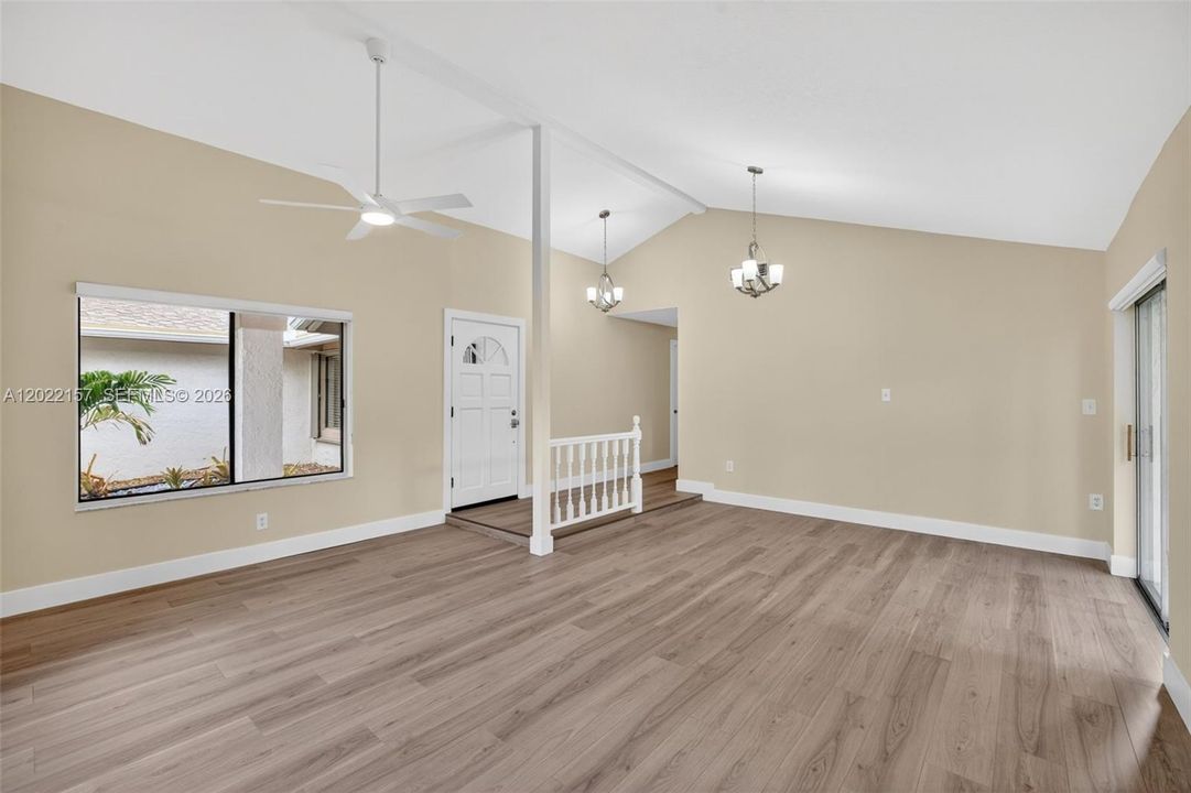 Entrance area and formal living area overlooking front of house, and dining area to the left. Windows with light filtering solar shades.