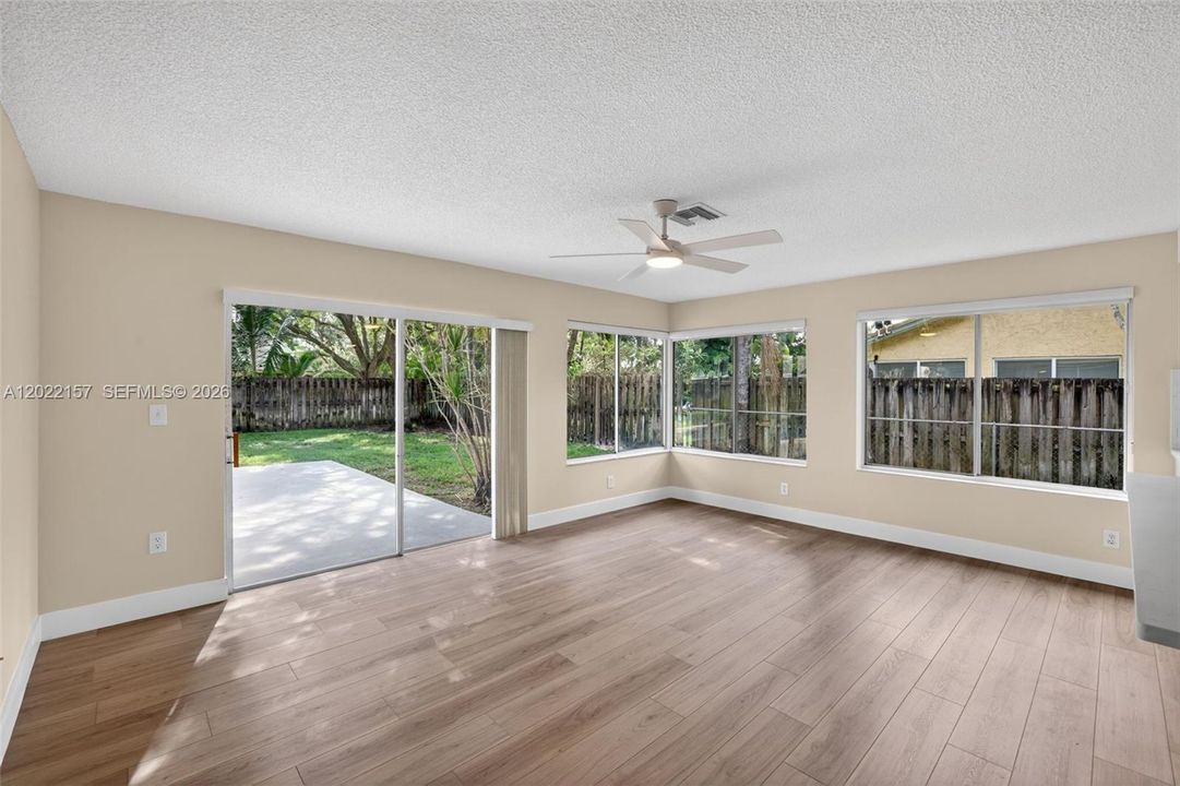 Family room connected to kitchen w/ sliders to patio / pool area and roller shades / light filtering window treatments
