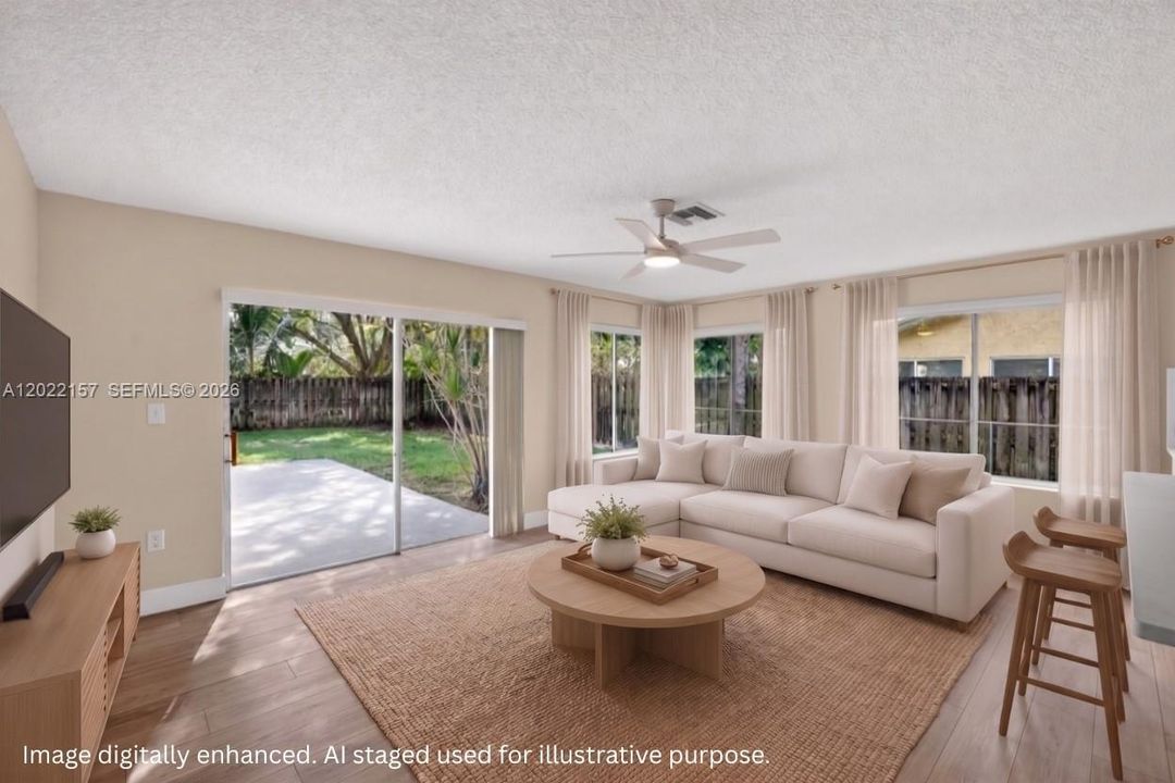 Bright family room space facing backyard for you to hang out in connected to kitchen. With Solar Shades. Virtual staging.