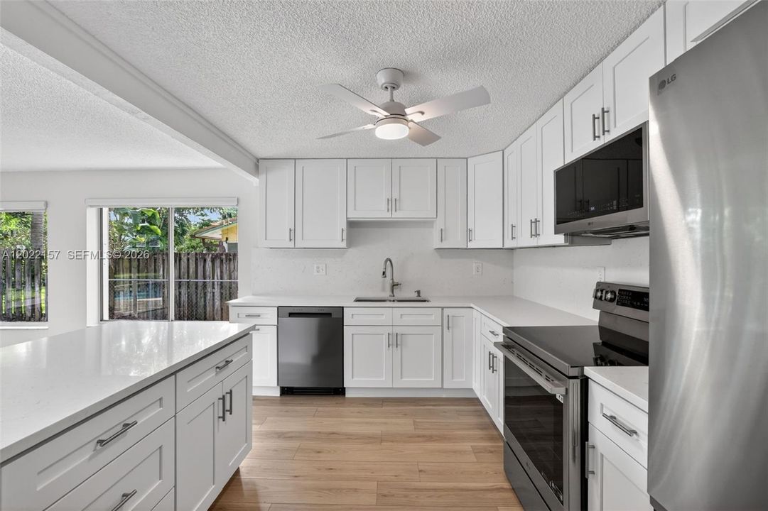 New beautiful kitchen w/ White Shaker style, slow close cabinets, quartz counters, and BRAND NEW appliances connected to family room