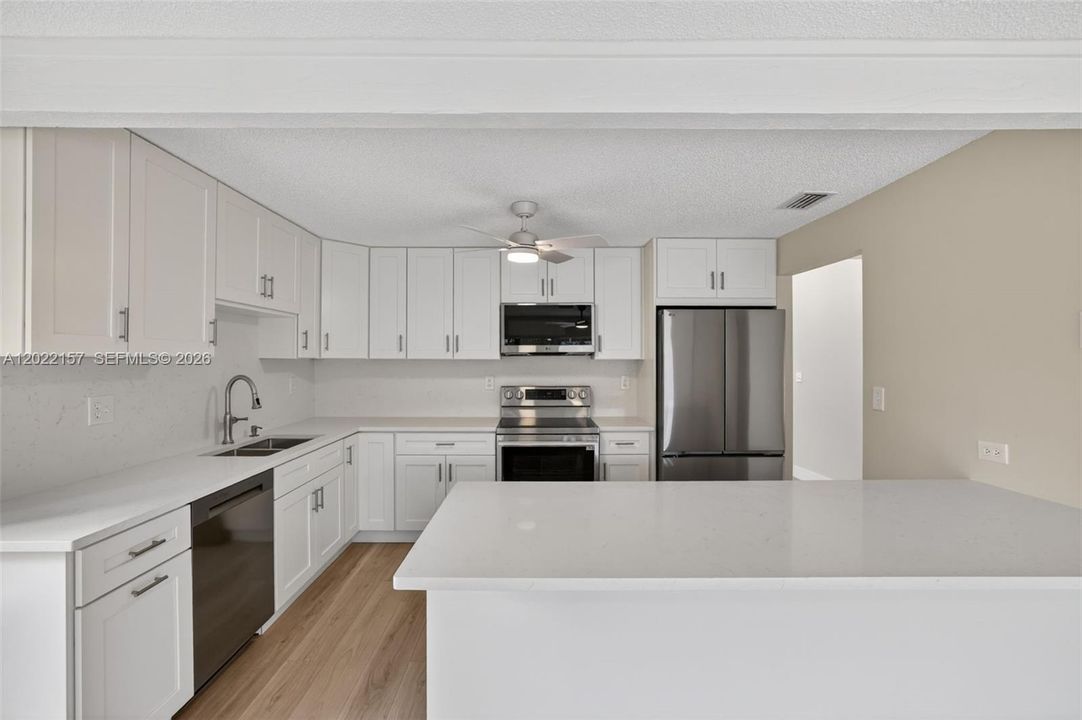 New beautiful kitchen w/ White Shaker style, slow close cabinets, quartz counters, and BRAND NEW appliances connected to family room