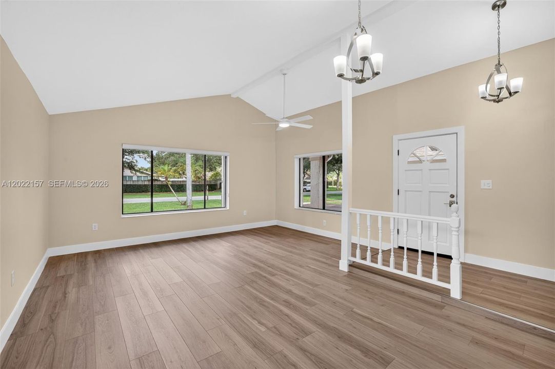 Entrance area and formal living area overlooking front of house, and dining area to the left. Windows with light filtering solar shades.