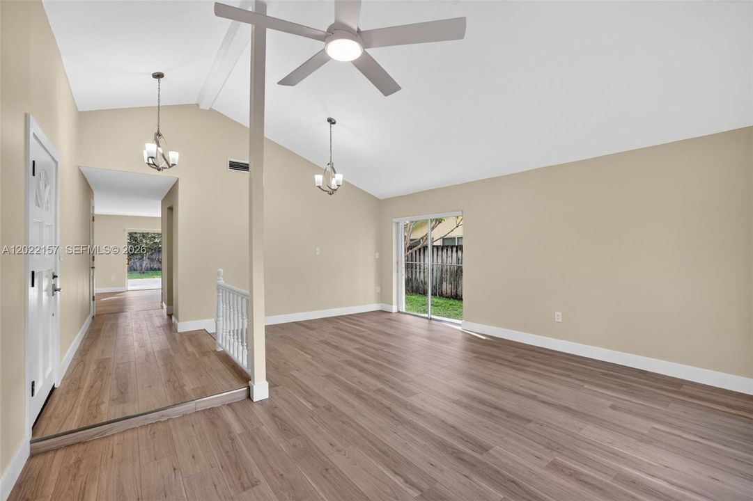 Entrance area and formal living area overlooking front of house, and dining area to the left. Windows with light filtering solar shades.