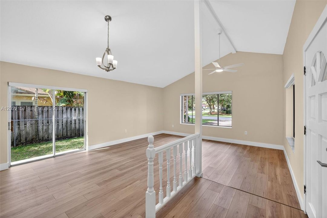 Entrance area and formal living area overlooking front of house, and dining area to the left. Windows with light filtering solar shades.
