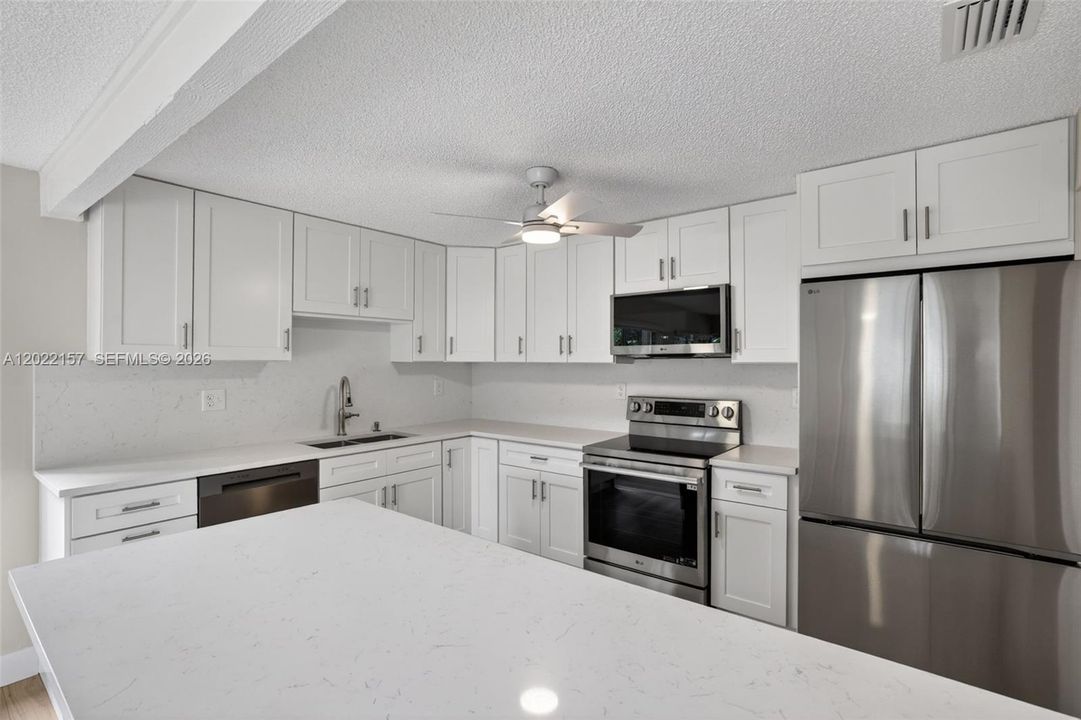 New beautiful kitchen w/ White Shaker style, slow close cabinets, quartz counters, and BRAND NEW appliances connected to family room