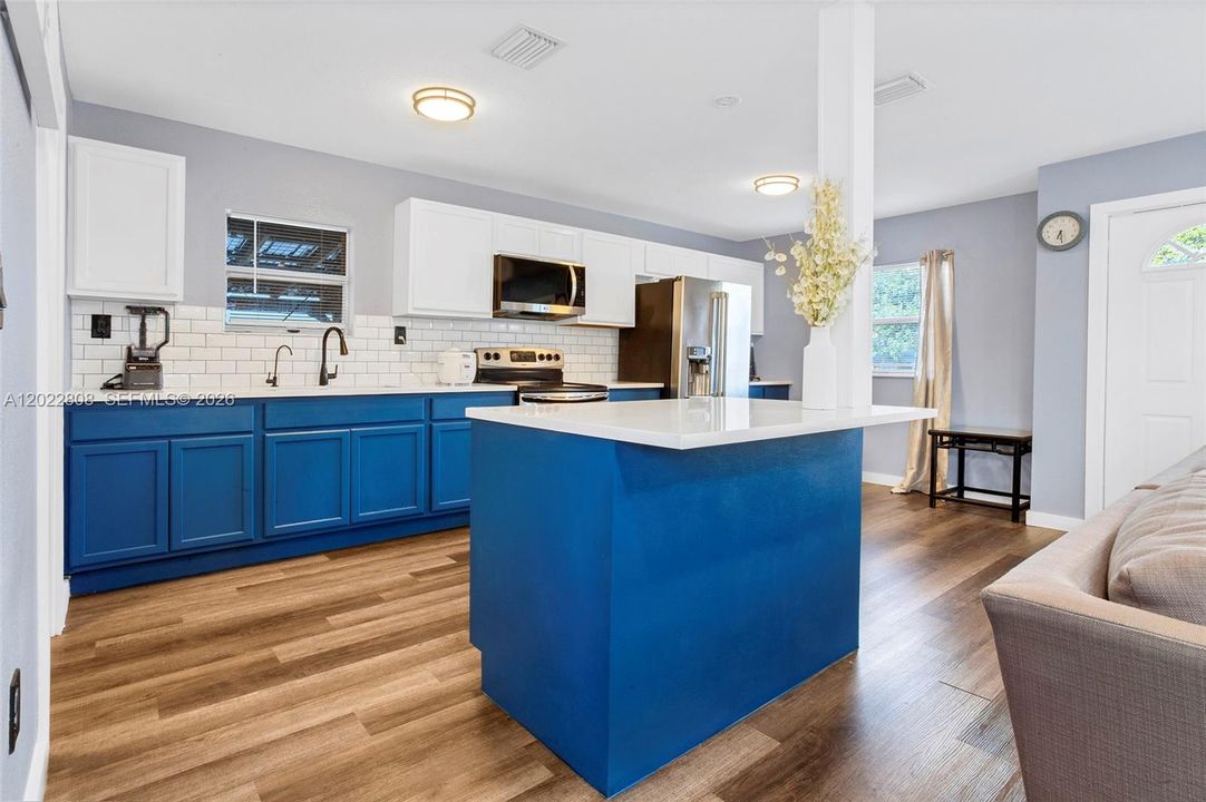 Bright open-concept family living area featuring modern flooring, recessed lighting, and a seamless flow to the kitchen—perfect for relaxing and entertaining.