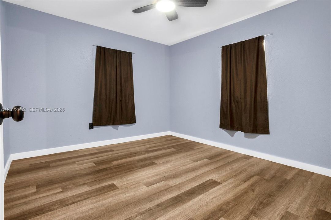 Versatile third bedroom featuring modern flooring, closet space, and abundant natural light—ideal as a guest room, home office, or bedroom.