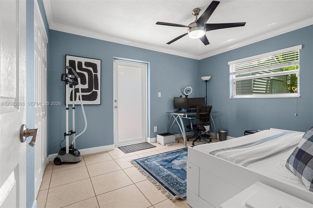 This bedroom can also serve as a home office, with its own private impact door leading to the backyard, providing easy access and added privacy