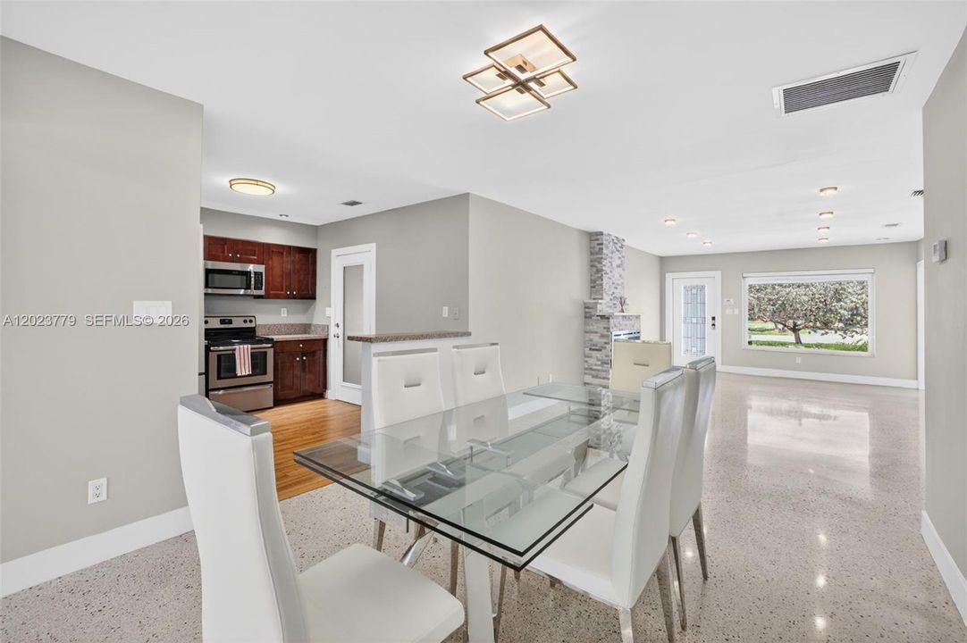 Dining area with flushmount fixture next to open concept kitchen