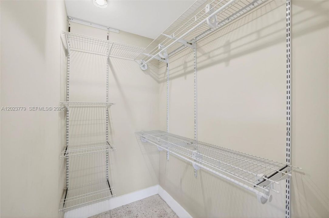 Primary walk in closet w/ upgraded adjustable shelving