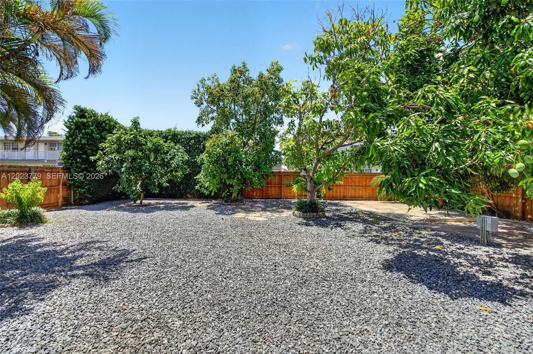 Large inviting backyard w/ stone chips and tons of fruit trees. Electric back gate to allow extra parking for your RV, Boat, Trailer or additional vehicles