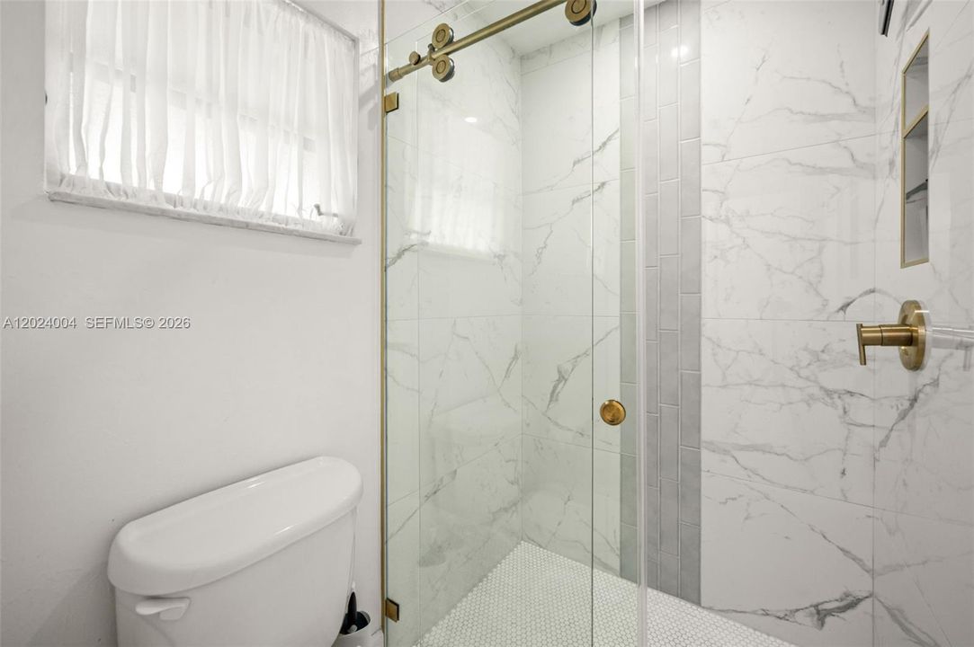 Primary bathroom with tiled glass wall shower