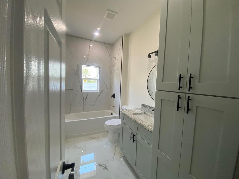 bath with tiled tub/shower combo