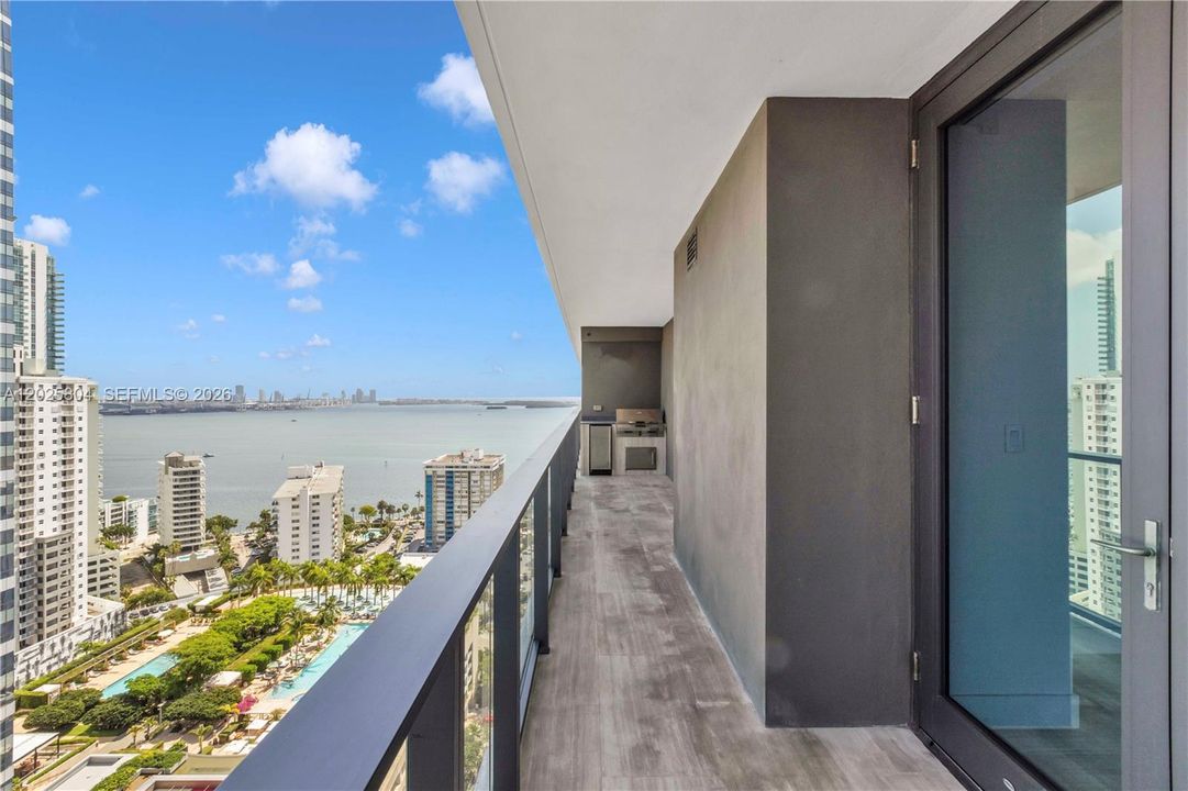 Balcony, South ocean view. There is a barbecue grill and a refrigerator.