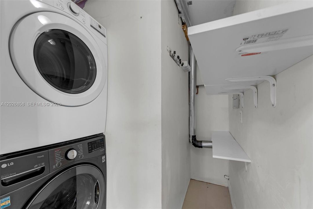 Dedicated laundry room with built-in shelving for added storage and organization.