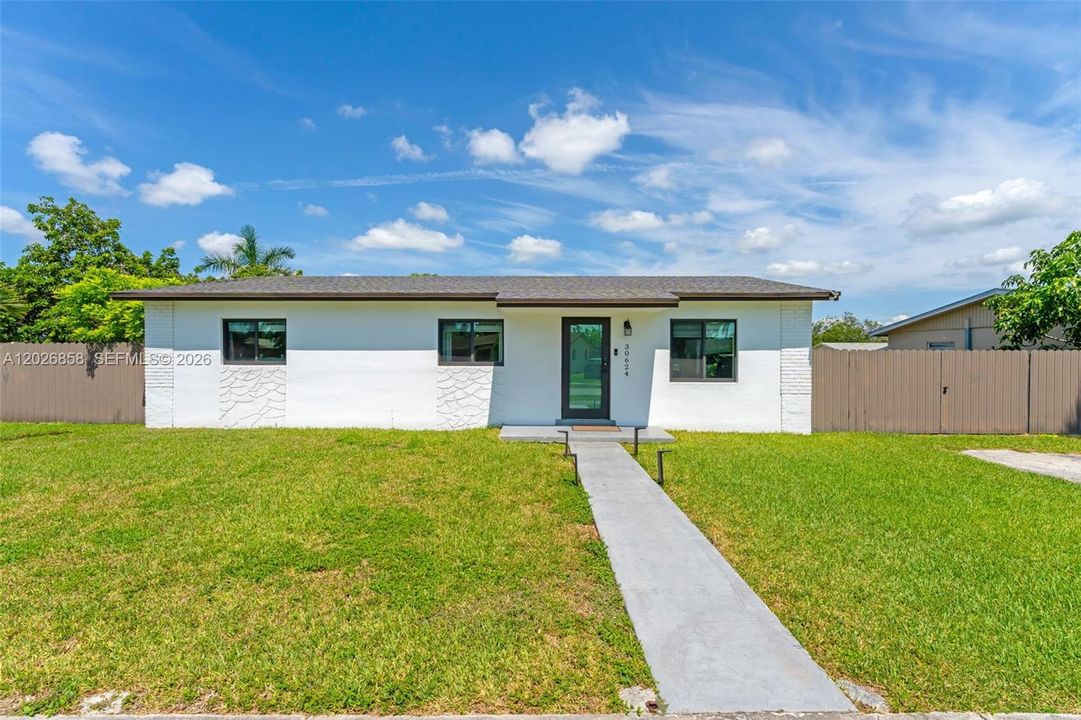 Modern curb appeal with fresh exterior paint, updated windows, and a spacious front yard.