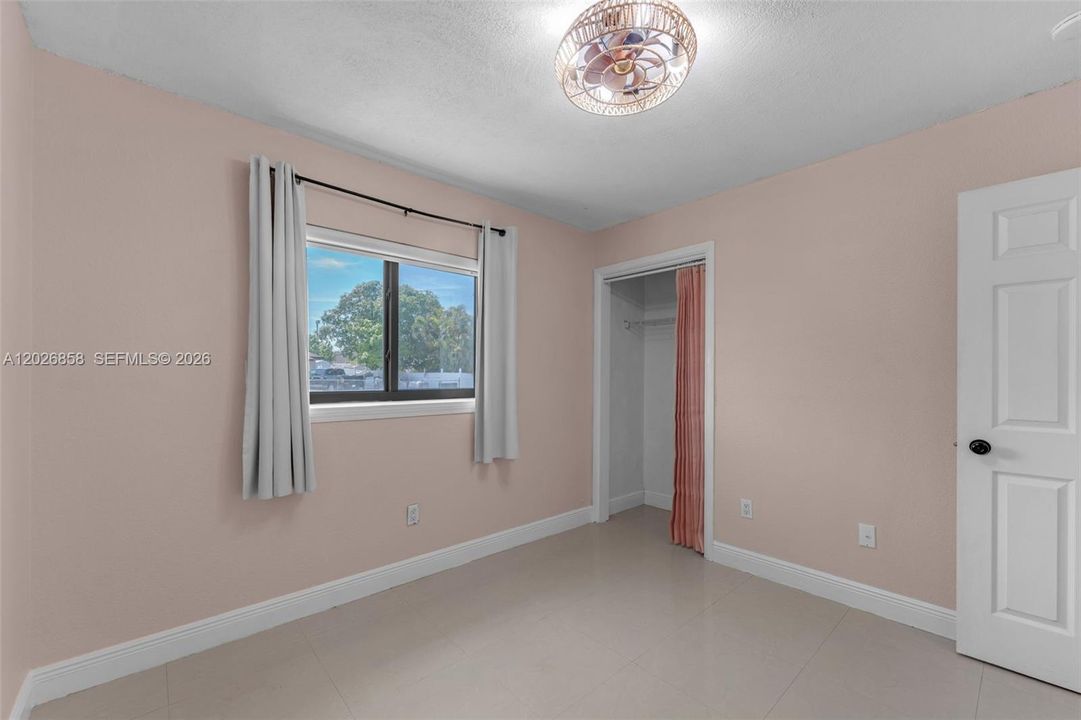 Secondary bedroom featuring an oversized closet and neutral finishes ready for your personal touch.