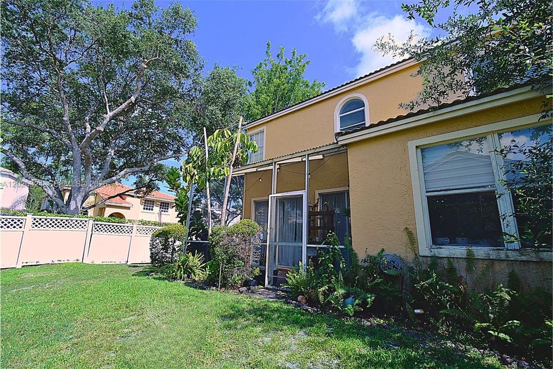 Private, well-kept backyard with lush greenery and tall hedges that create a peaceful, secluded outdoor space