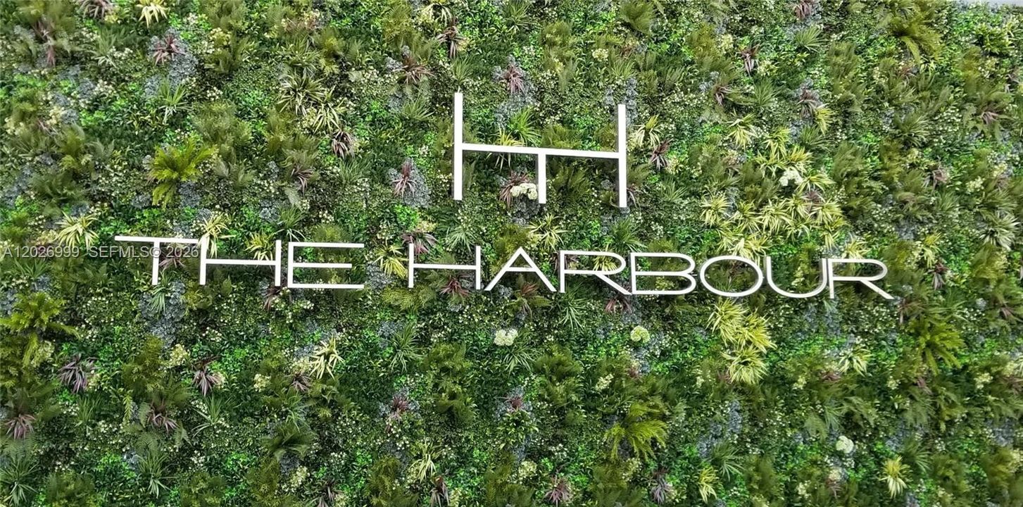 A lush vertical garden wall with The Harbour signage creates a polished arrival detail. The greenery adds a fresh, modern touch to the building’s shared spaces.