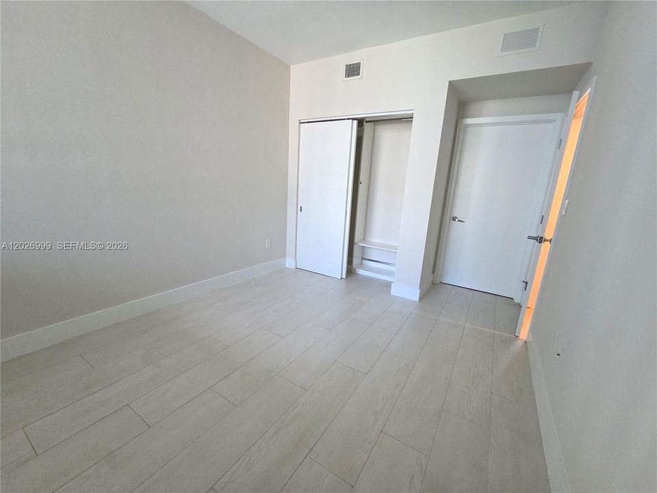 Secondary angle highlighting the bedroom layout with access to the closet and adjoining hallway, offering a clear flow between living spaces.