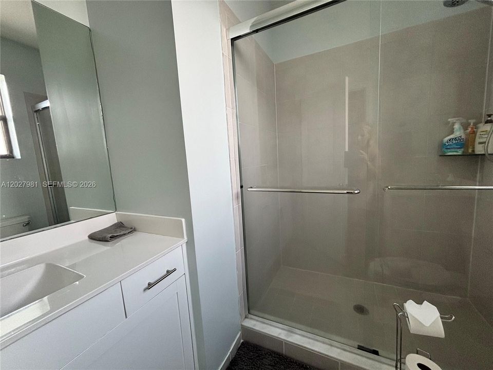 Spacious shower with custom high pressure shower head and glass enclosure