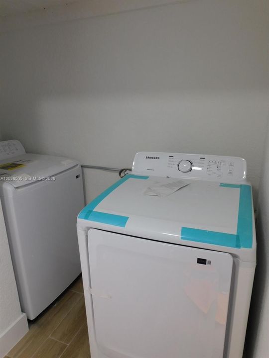 Newer washer and dryer combo in laundry room.
