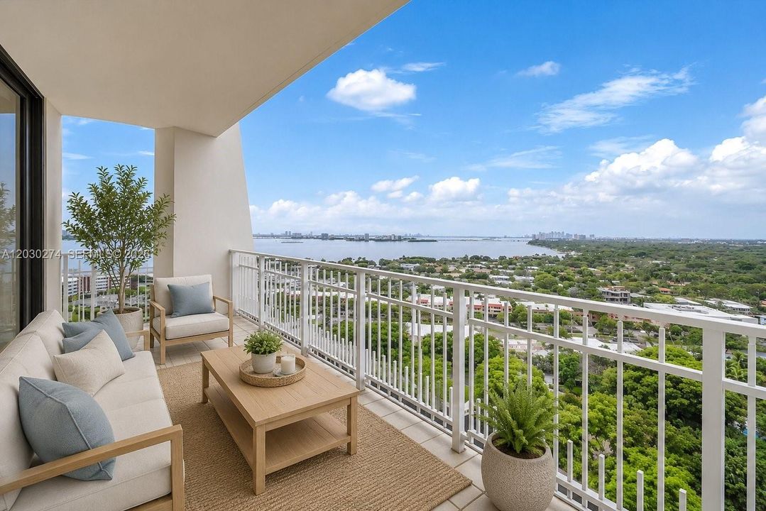 DIGITALLY STAGED BALCONY WITH VIEWS OF MIAMI WATERWAY AND LUSH GREEN SPACE.