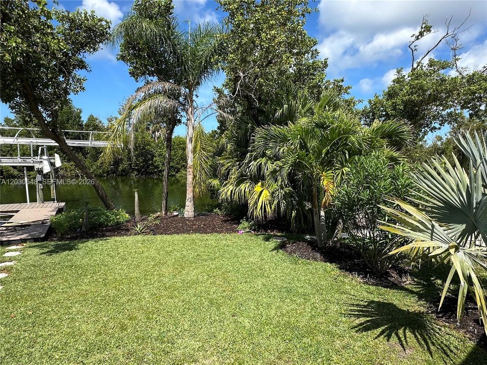 Mature palms, tropical landscaping, and lush greenery surround the property, creating exceptional wall privacy and a true backyard oasis