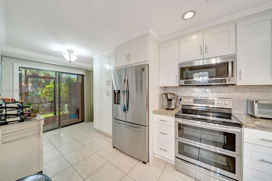 Sliders off the kitchen lead to a screened enclosed back porch
