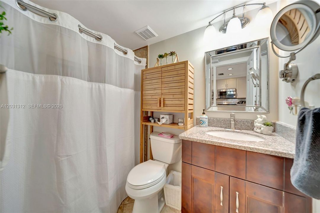 Downstairs full guest bathroom with tub/shower and upgraded vanity/mirror/lighting