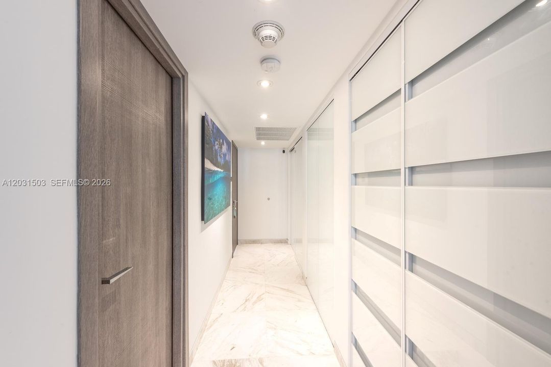 Hallway to bedrooms with closets concealed behind doors.