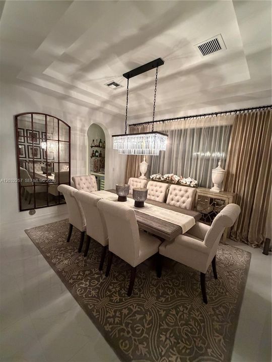 MAIN DINING ROOM WITH DOUBLE TRAY CEILING, DECORATED WITH A DESIGNER GLASS CHANDELIER