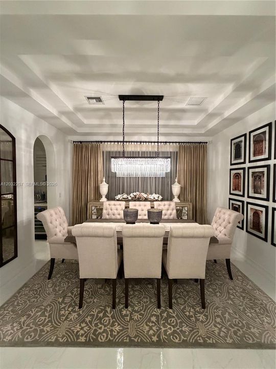 MAIN DINING ROOM WITH ARCHED ENTRYWAY LEADING TO KITCHEN AREA.
