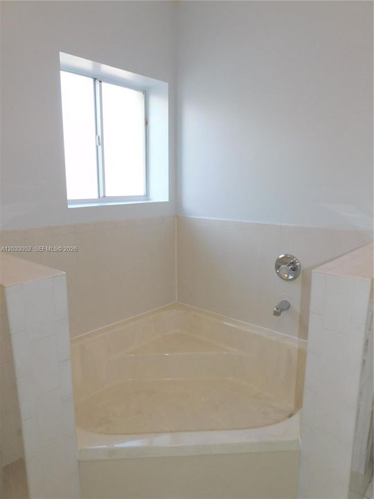 Large roman tub separates the 2 vanities.
