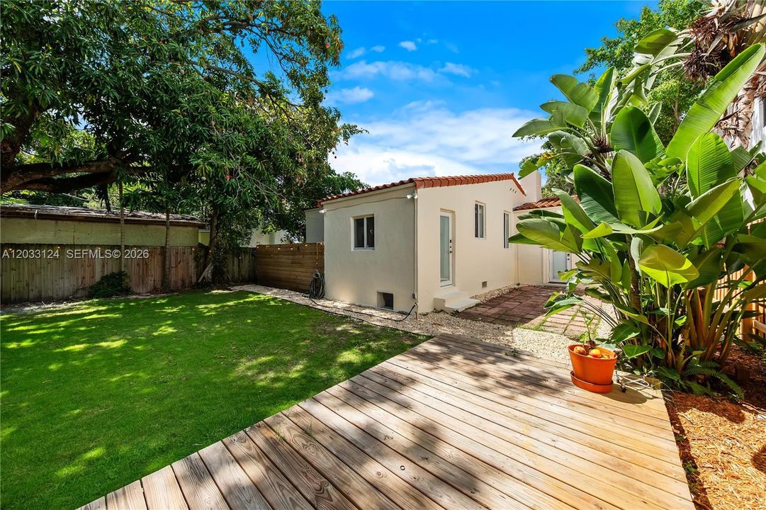 Large yard with mango tree and deck