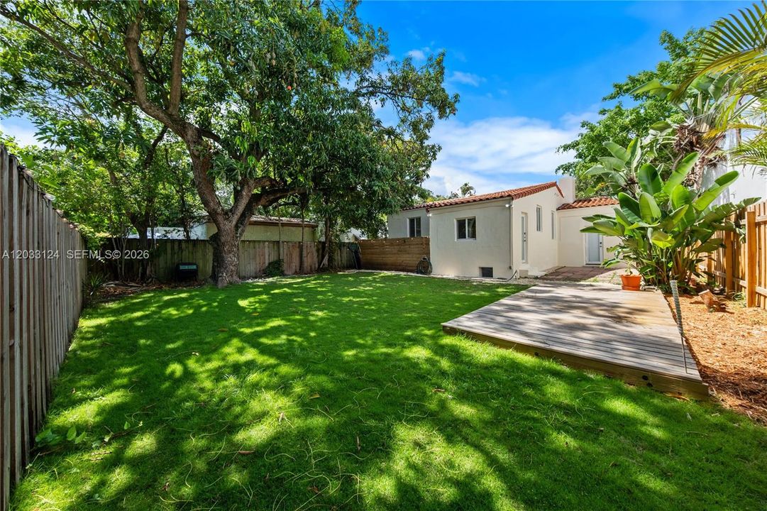 Large yard with mango tree and deck