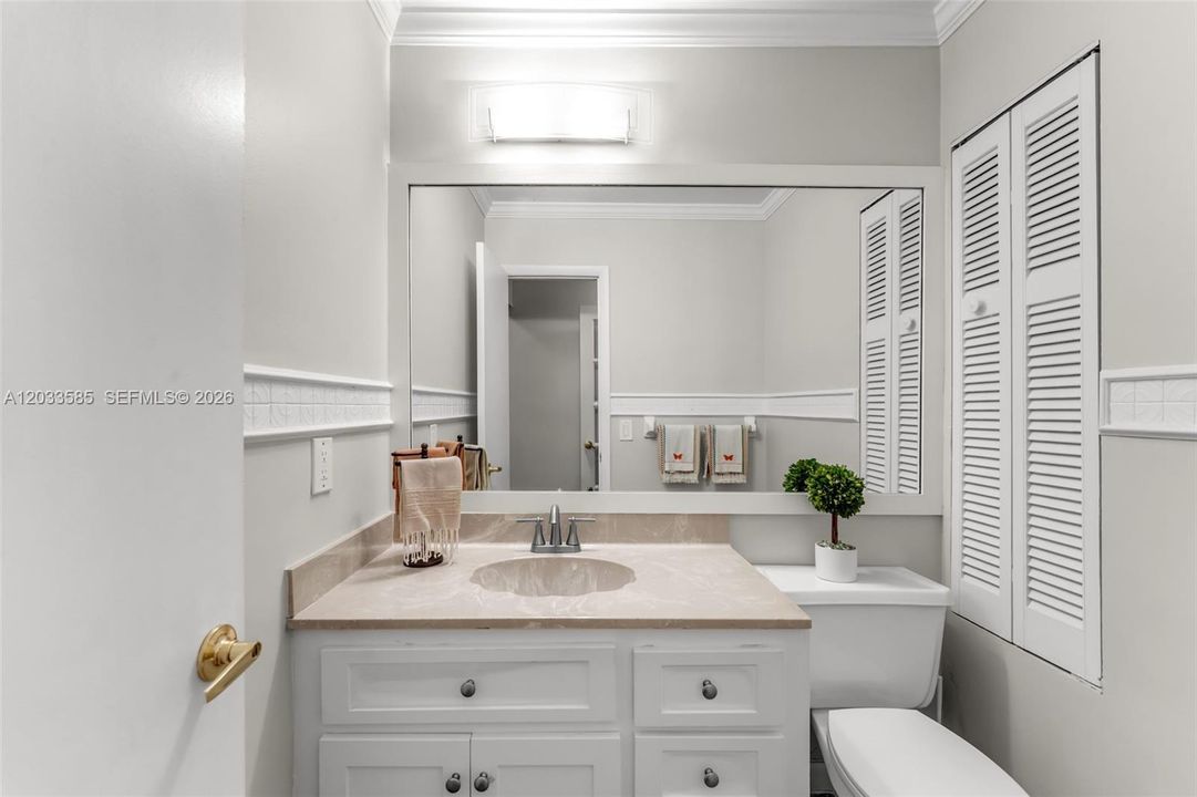 Half bathroom with storage closet.