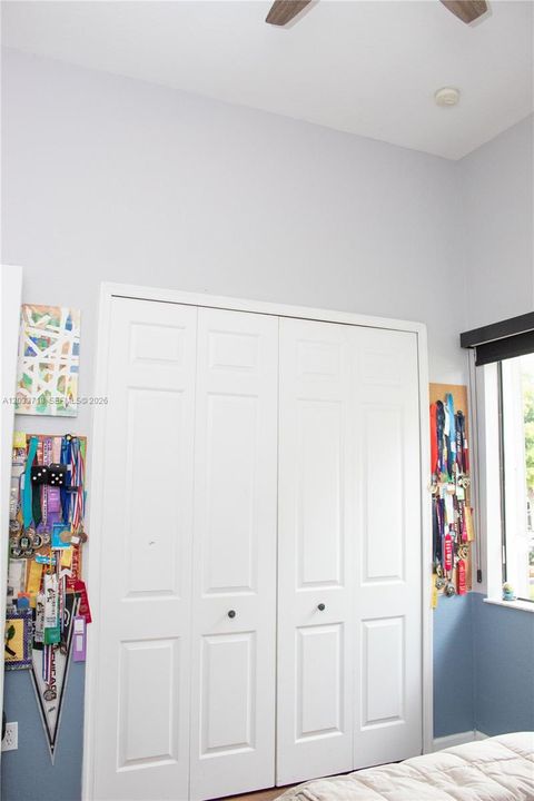 Shelving System and wonderful storage in First Bedroom. Natural light through window facing the front of the home. This bedroom connects to a bathroom, which also connects to the Second Bedroom. So this is a Jack-and-Jill but L-Shaped.