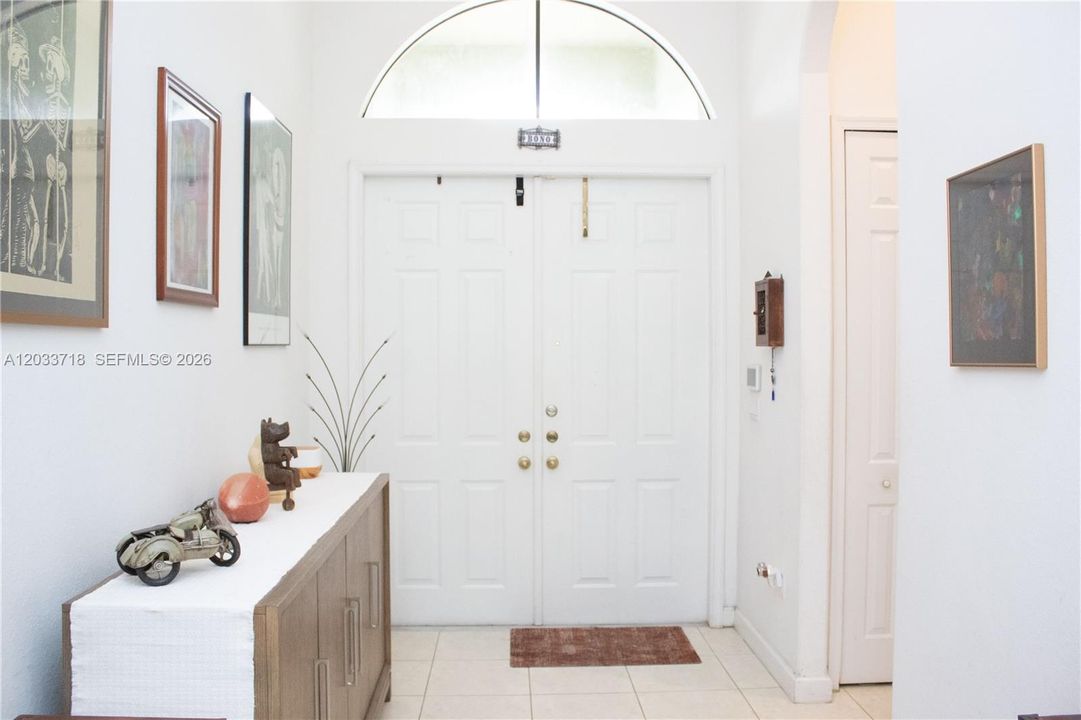 right by the front door, there is a hallway seen here in the right, that leads to the Jack-and-Jill bedrooms and bathroom as well as to the Laundry Room. Then behind this photo, on the left, there is another hallway that leads to the Garage Entrance, the Third Bedroom, the Second Bathroom as well as the AC closet (AC replaced 2021).