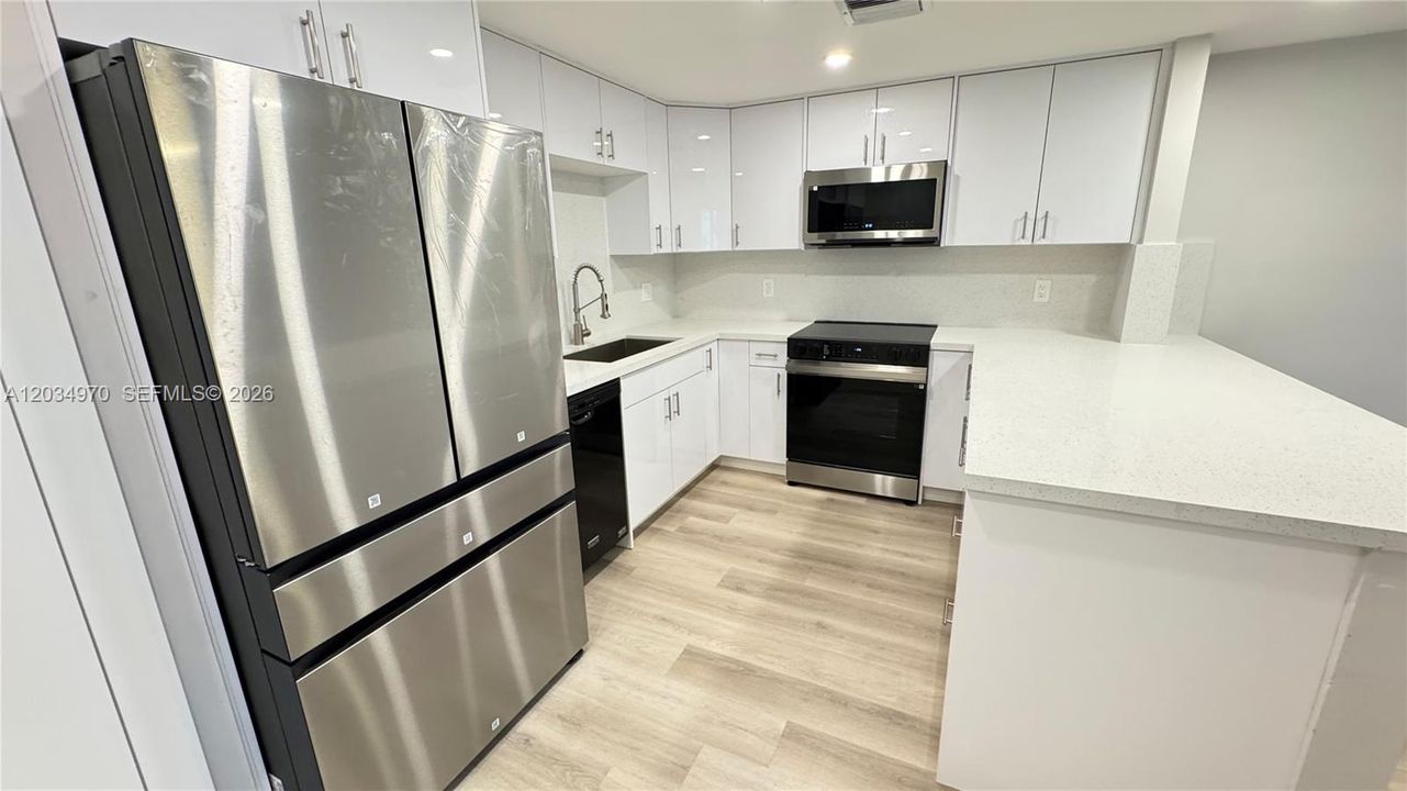 "Brand-new kitchen with new cabinetry, stainless steel appliances, and a pantry closet