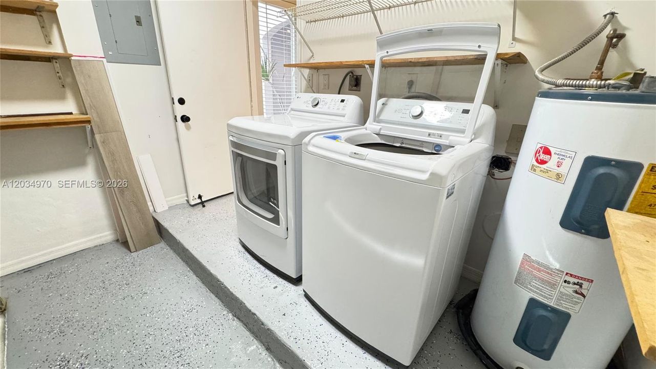 Separate laundry area off the family room featuring additional shelving to maximize storage space.