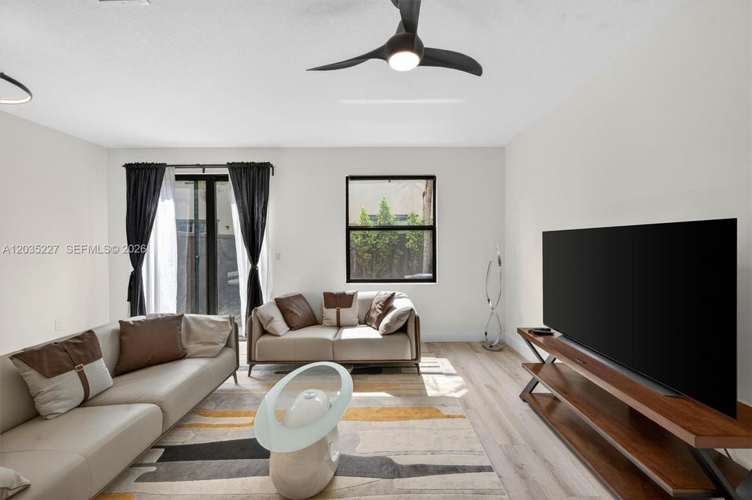 Stylish living space complete with a modern ceiling fan and ample natural light.